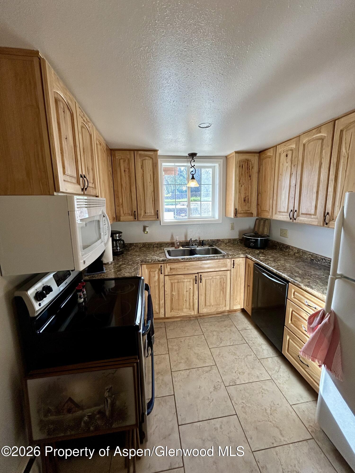 730 Green Street Craig, CO 81625 - Photo 21 of 34 a kitchen with a stove a sink and a microwave