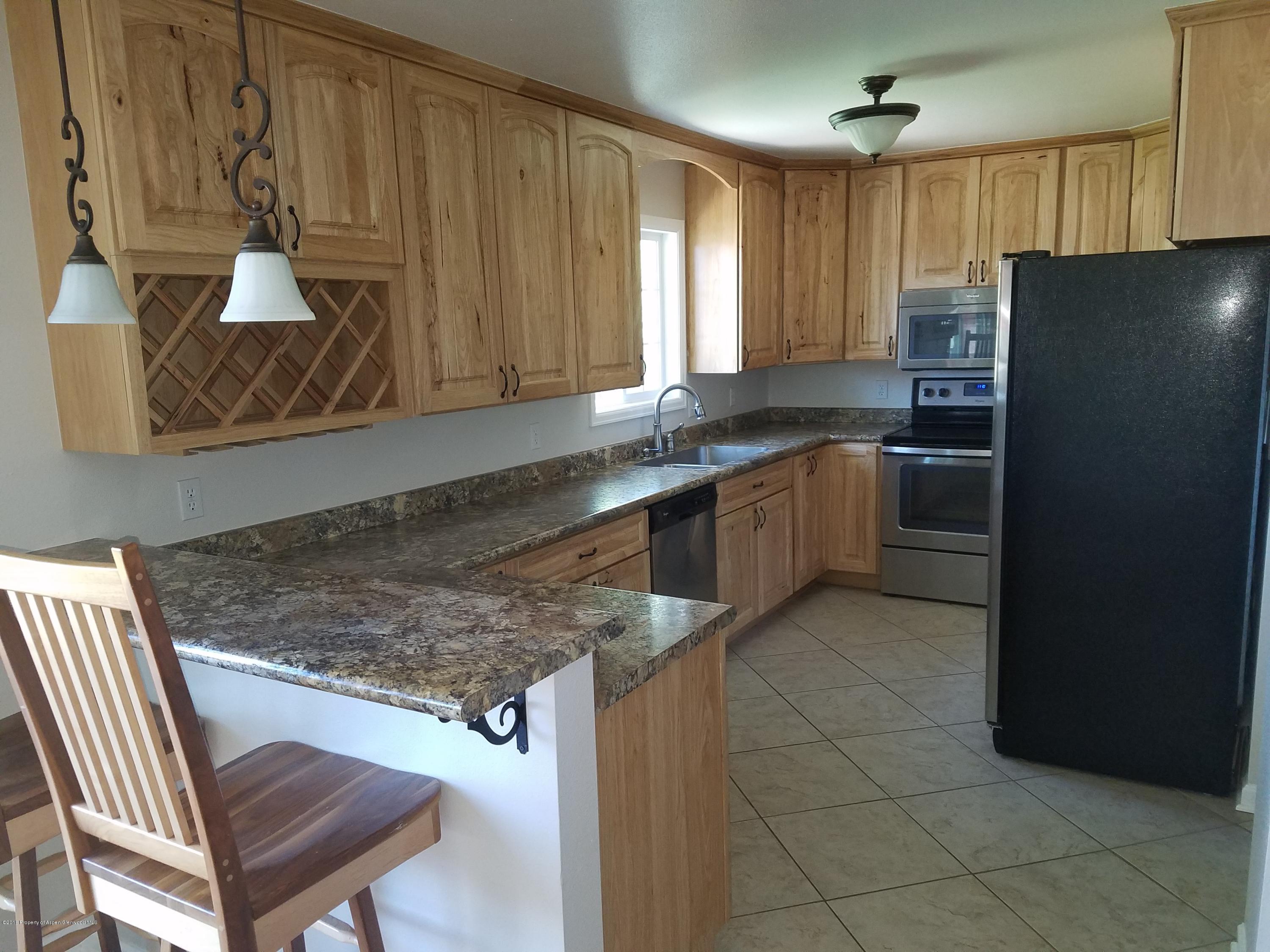 730 Green Street Craig, CO 81625 - Photo 6 of 34 a kitchen with stainless steel appliances granite countertop a sink refrigerator and microwave