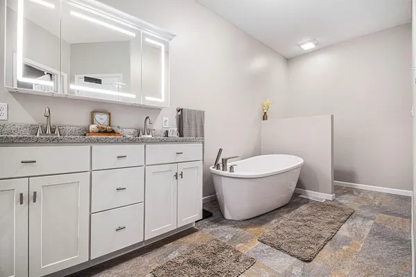 a bathroom with a granite countertop sink mirror vanity and toilet