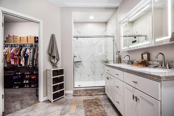 a view of walk in closet with clothes and shoes