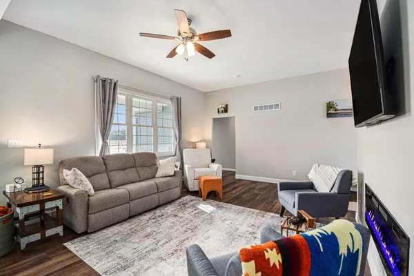 a living room with furniture ceiling fan and a window