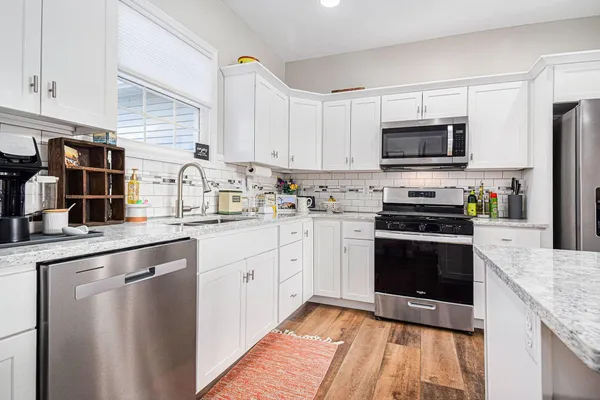 a kitchen with stainless steel appliances granite countertop a stove a sink and a refrigerator