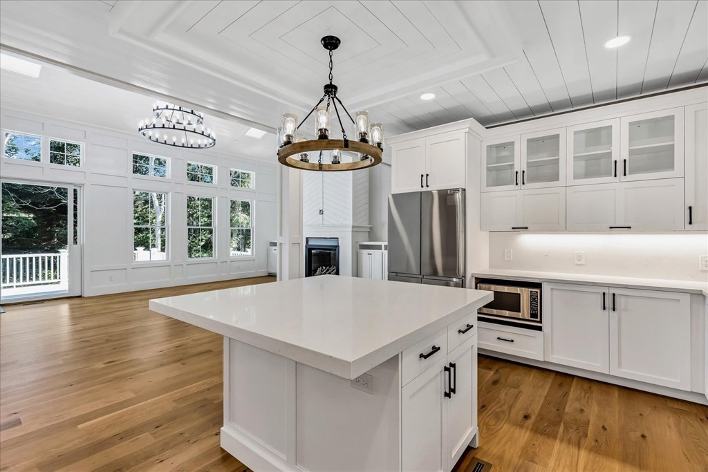 58 Amos Landing Road Mashpee, MA 02649 - Photo 20 of 42 a kitchen with stainless steel appliances a stove a refrigerator a sink and white cabinets with wooden floor