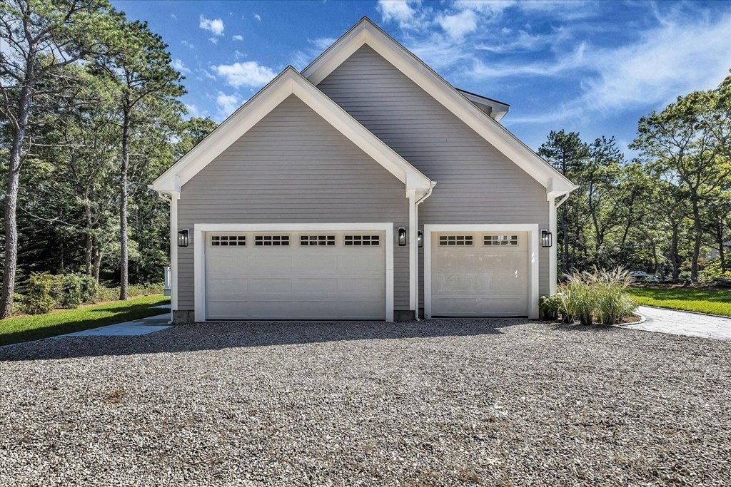 58 Amos Landing Road Mashpee, MA 02649 - Photo 9 of 42 a view of a house with a yard and garage