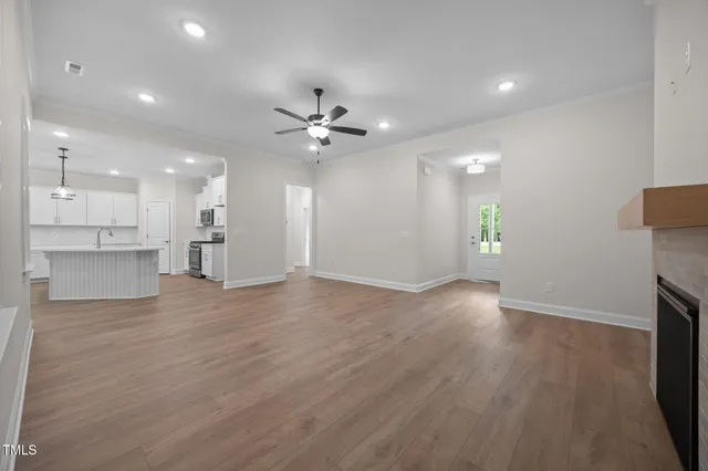 wooden floor in an empty room with a kitchen