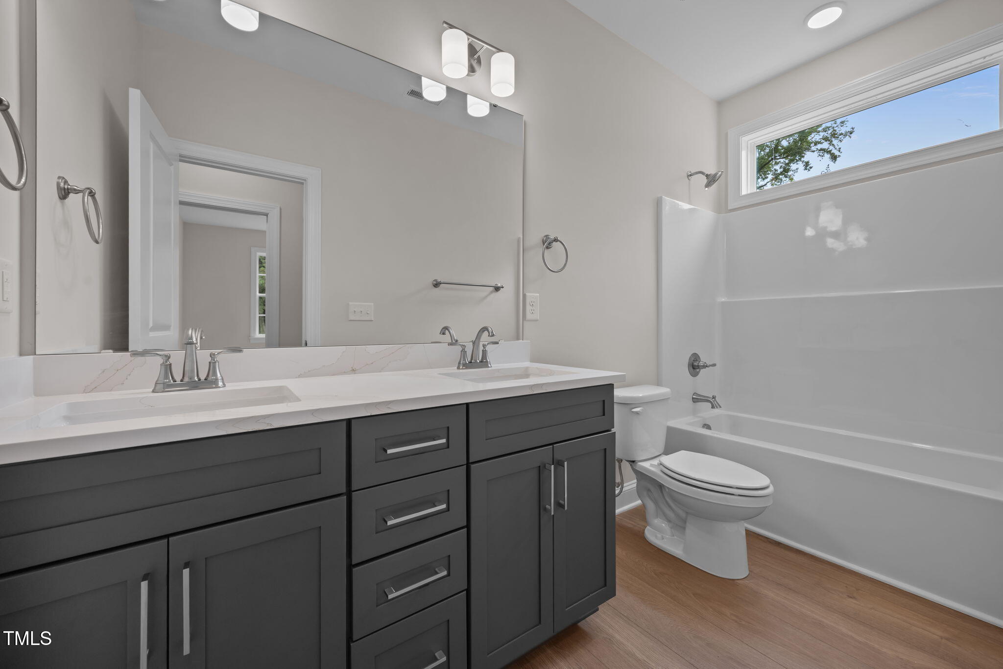 109 Drew Street Louisburg, NC 27549 - Photo 19 of 30 a bathroom with a double vanity sink a toilet a mirror and shower