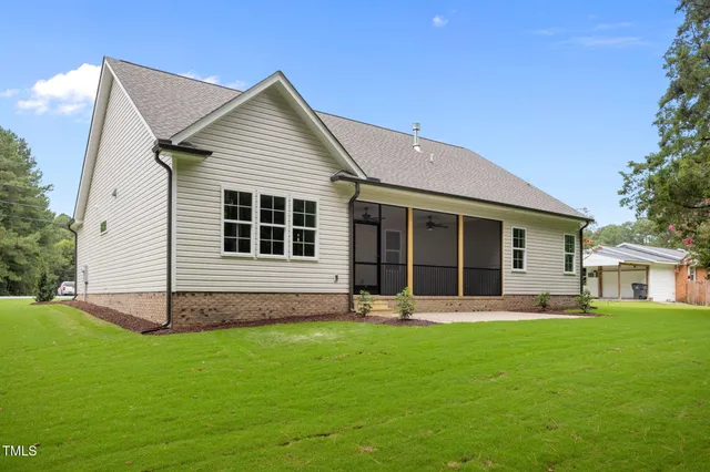 a front view of house with a garden and trees
