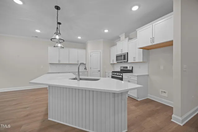 a kitchen with kitchen island a sink stainless steel appliances and cabinets