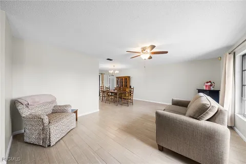 a living room with furniture and a dining table with bookshelf