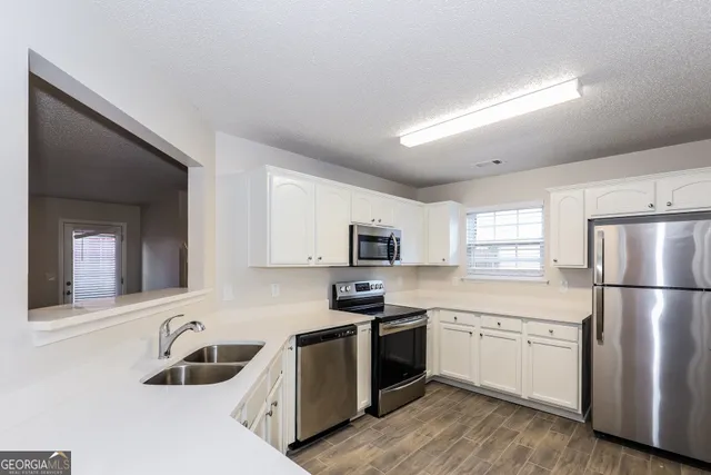 a kitchen with a sink a stove and refrigerator
