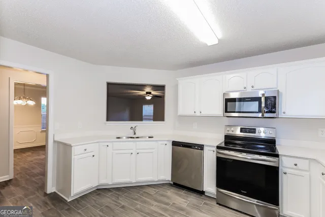 a kitchen with stainless steel appliances white cabinets and a sink