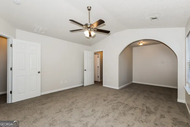 a view of a room with a ceiling fan and window