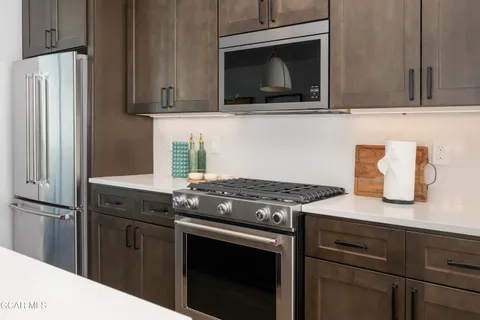 a kitchen with stainless steel appliances granite countertop a stove microwave and refrigerator