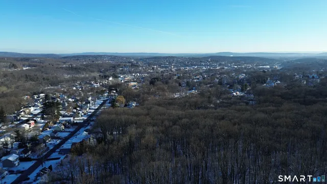 an aerial view of house with yard and mountain view in back