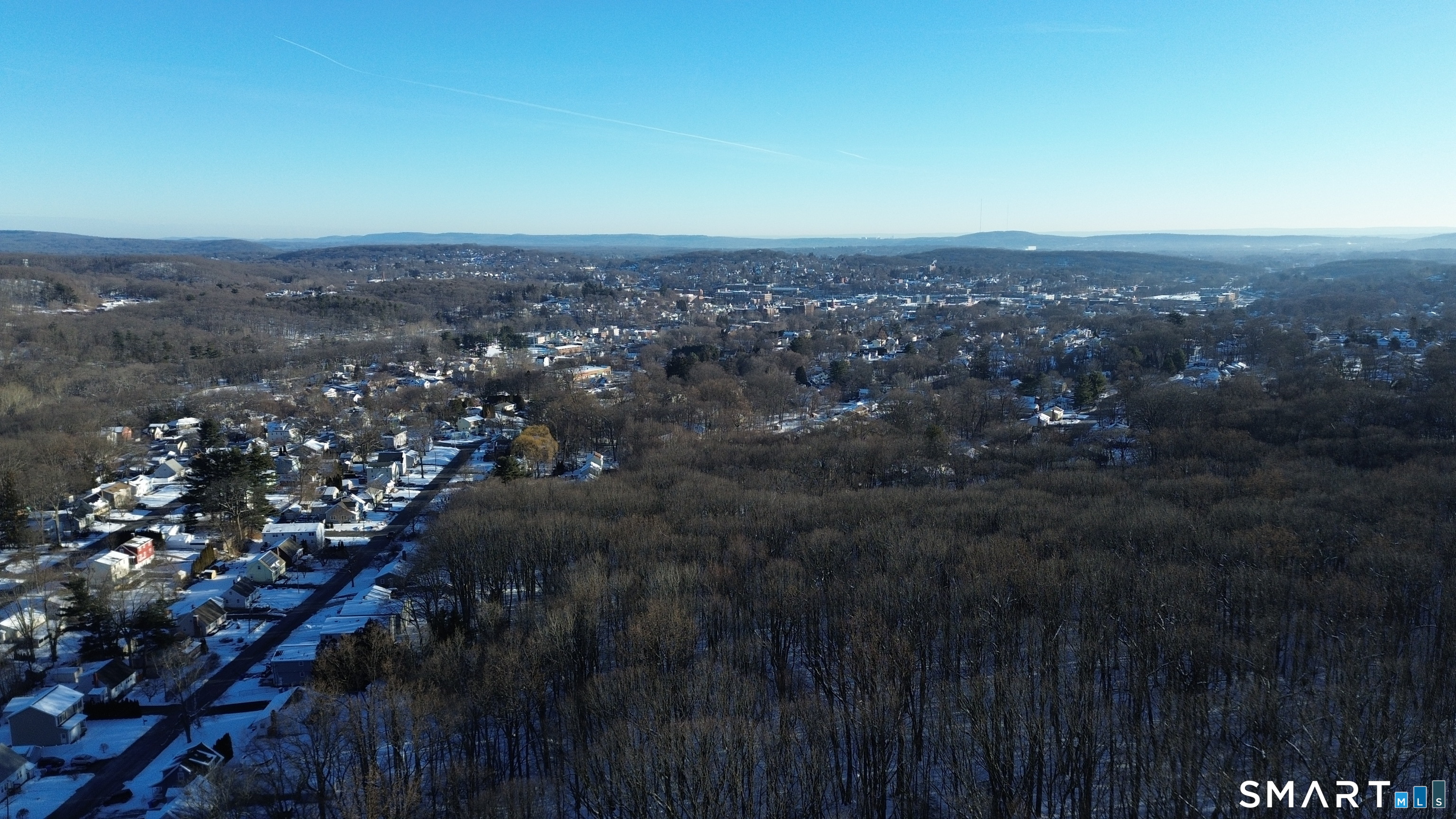 an aerial view of house with yard and mountain view in back