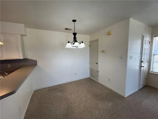 a view of empty room with chandelier