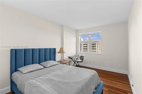 a bed sitting in a spacious bedroom next to a window