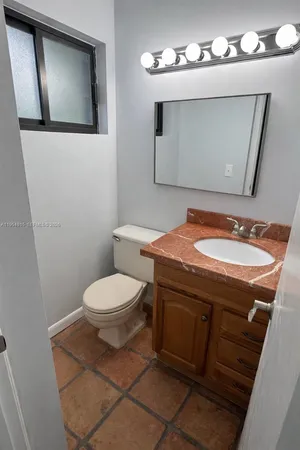 a bathroom with a toilet a sink and mirror