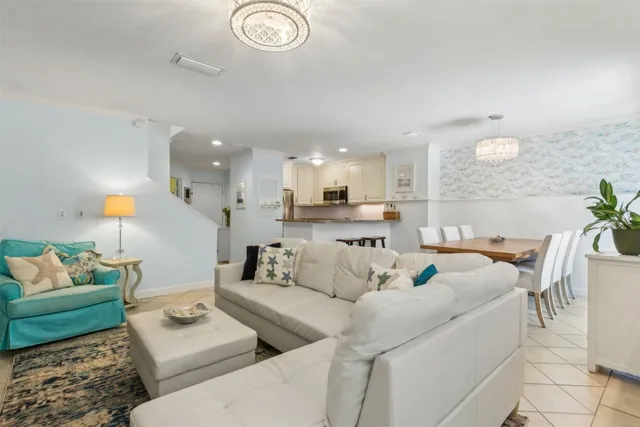 a living room with furniture and a view of kitchen