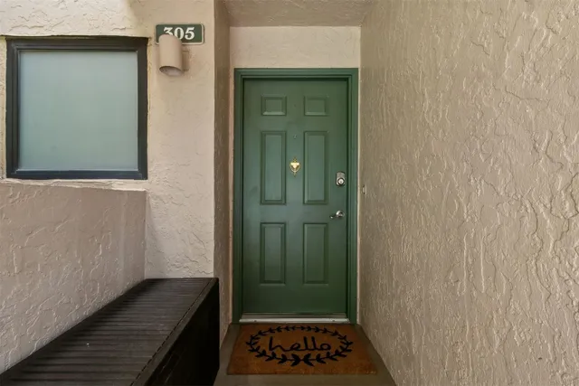 a view of a hallway with wooden floor and a bathroom