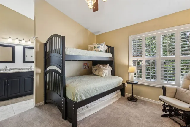 a bathroom with a granite countertop sink vanity mirror bathtub shower and a mirror