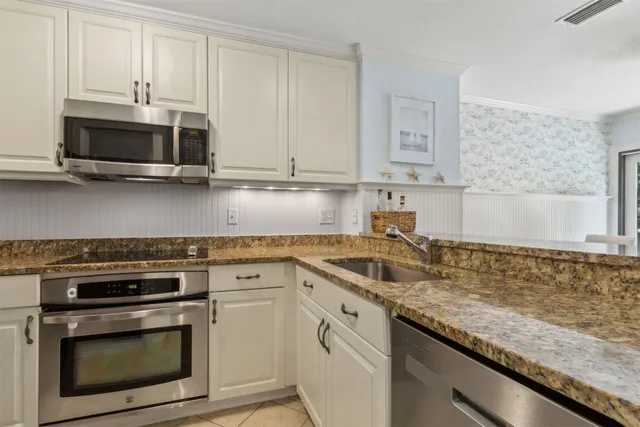a kitchen with stainless steel appliances granite countertop a sink stove and microwave