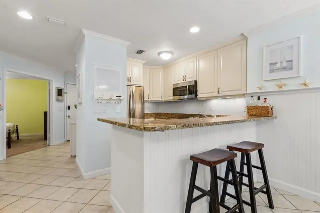 a kitchen with stainless steel appliances granite countertop a sink and a refrigerator