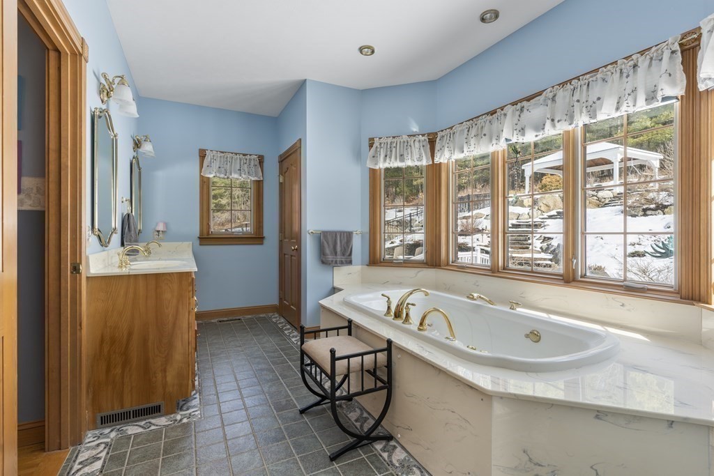 171 Scantic Road Hampden, MA 01036 - Photo 19 of 42 a bathroom with a tub a sink and a large mirror next to a window