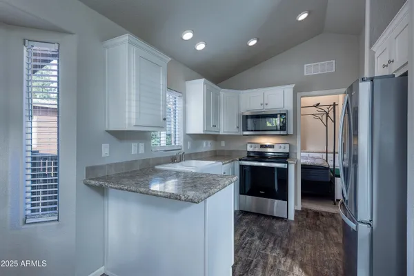 a kitchen with stainless steel appliances granite countertop a stove a sink and a refrigerator