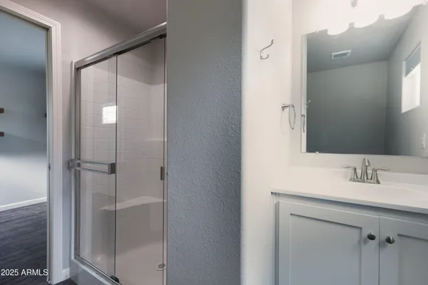 a bathroom with a shower sink and mirror