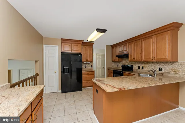 a kitchen with a refrigerator sink and cabinets