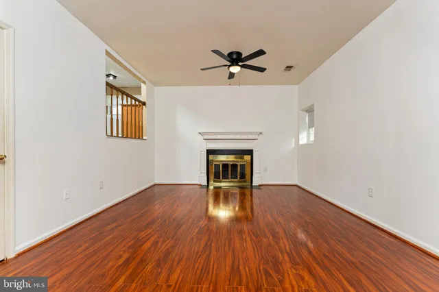 a view of empty room with wooden floor and fireplace