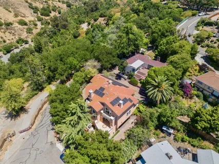 an aerial view of residential houses with outdoor space and trees