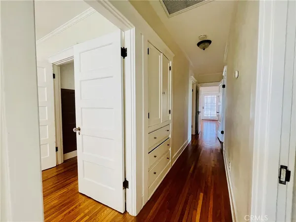 a view of a hallway with wooden floor and staircase