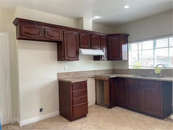 a kitchen with stainless steel appliances granite countertop a sink and cabinets with wooden floor