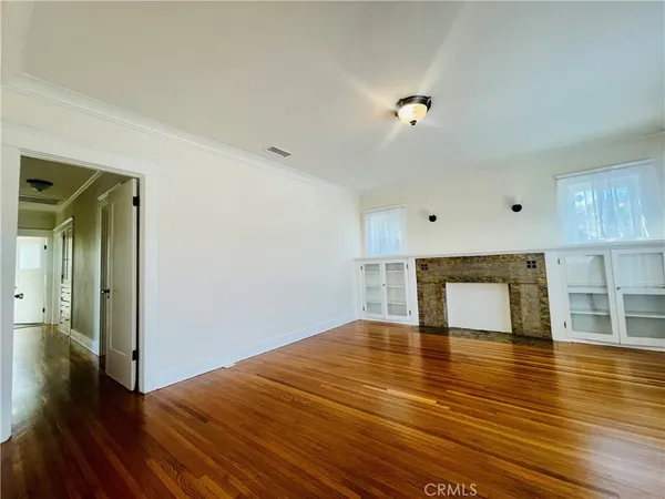 a view of empty room with wooden floor