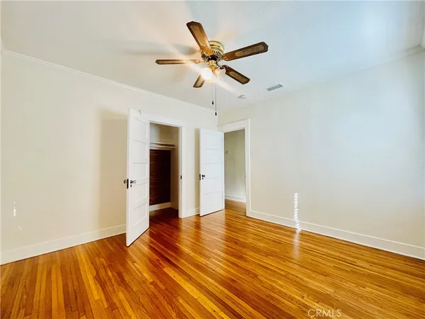 a view of room with wooden floor and ceiling fan