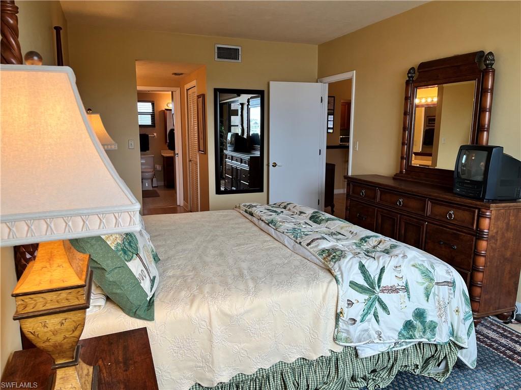 807 River Point Drive, Unit 304D Naples, FL 34102 - Photo 13 of 23 a bedroom with a bed and dresser with mirror