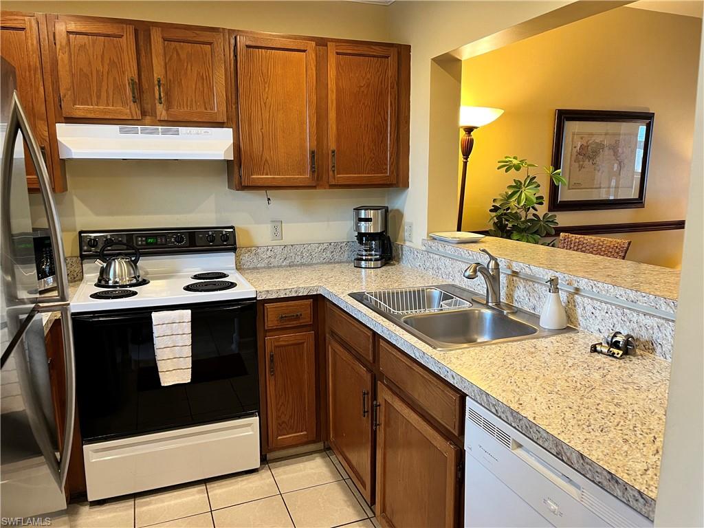 807 River Point Drive, Unit 304D Naples, FL 34102 - Photo 9 of 23 a kitchen with granite countertop a sink stove and microwave