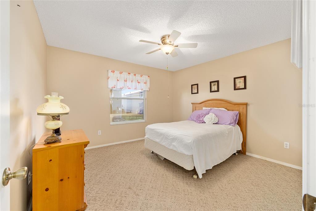 1710 Rosales Road The Villages, FL 32162 - Photo 14 of 23 a bedroom with a bed and a chandelier