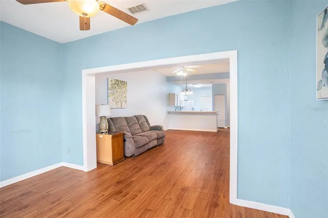 a living room with furniture and a wooden floor