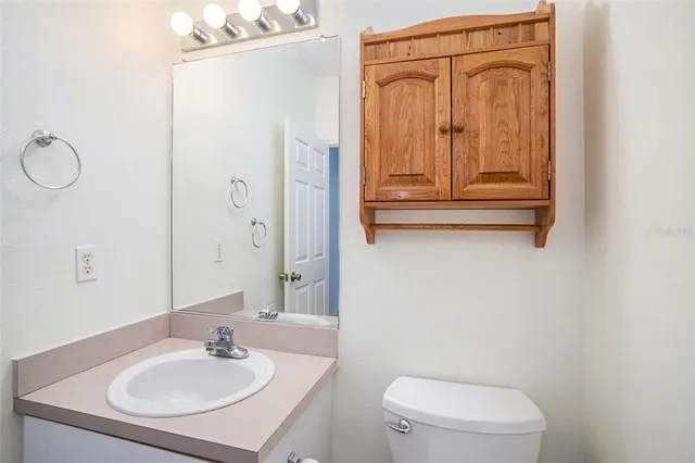 a bathroom with a sink a toilet and a mirror