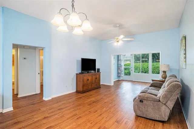 a living room with furniture a flat screen tv and a large window