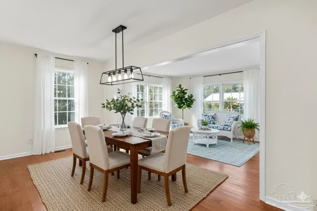 a dining room with furniture a chandelier and wooden floor