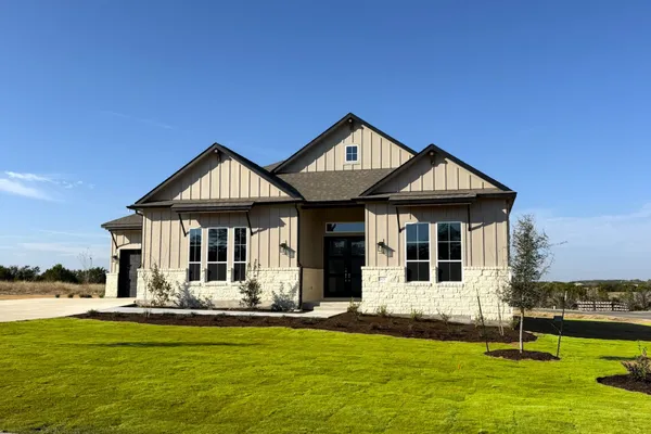 a view of a white house with a big yard and potted plants