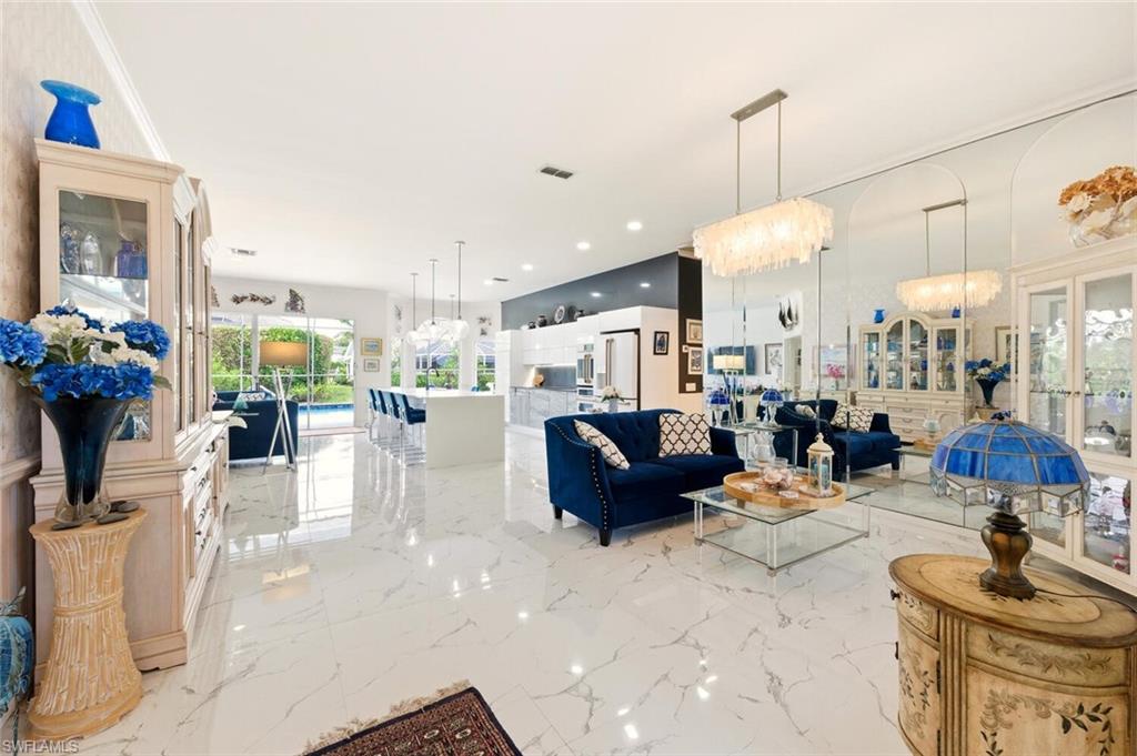 209 Countryside Drive Naples, FL 34104 - Photo 4 of 50 Living area with hanging lights and light marble finish flooring