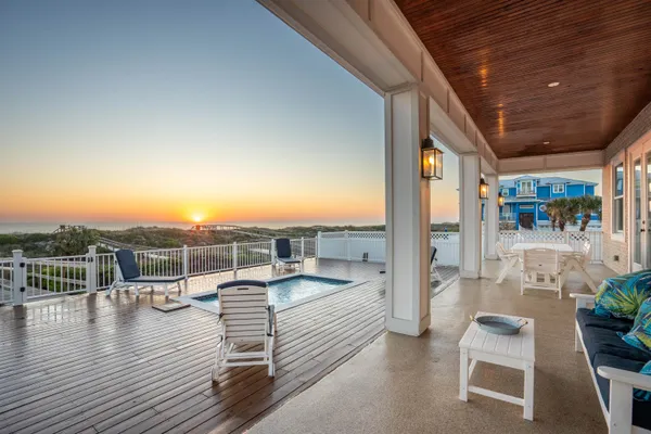 a view of a house with potted plants and a chair