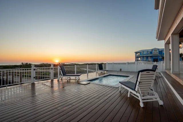a backyard of a house with wooden floor and outdoor seating