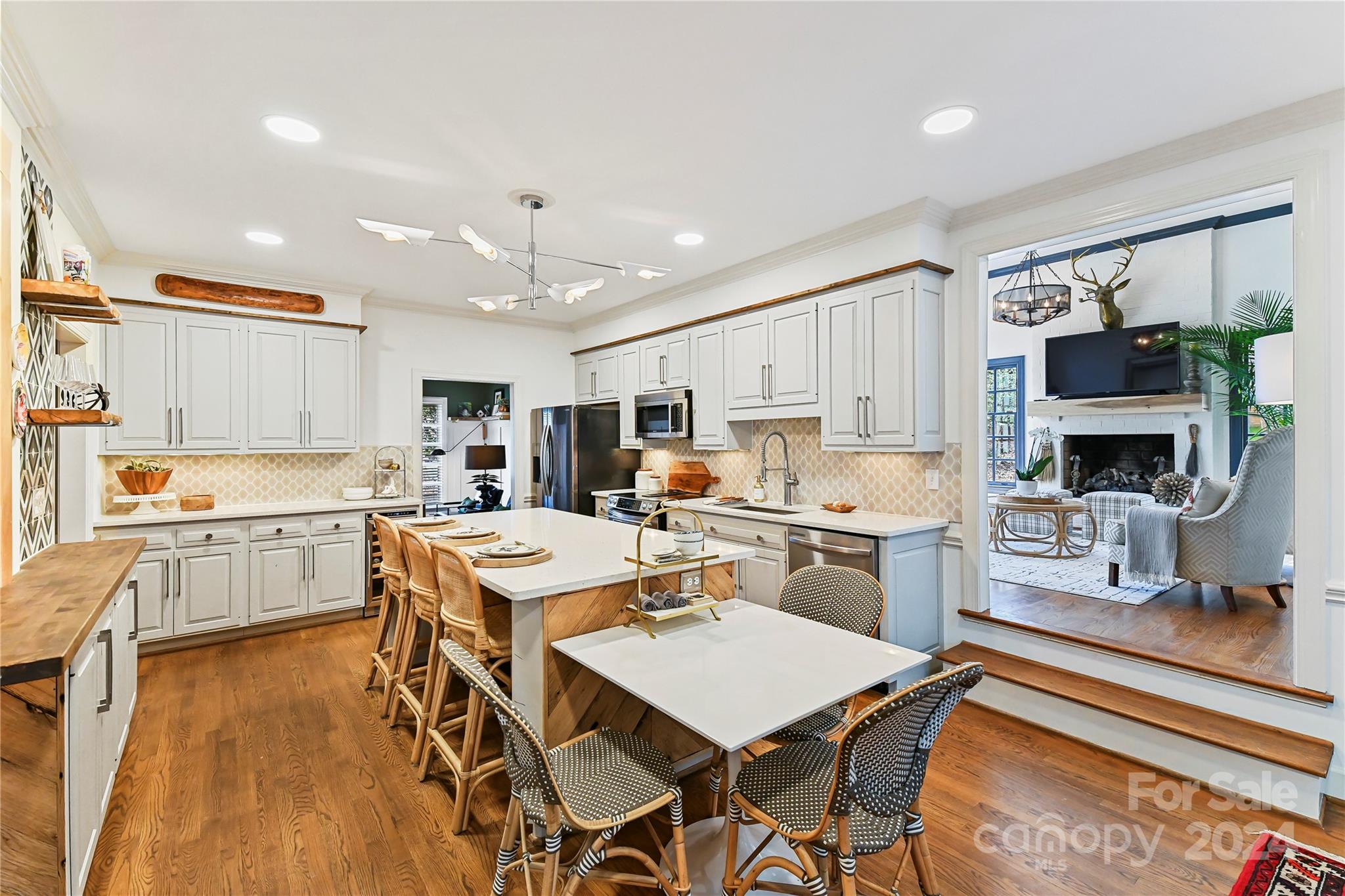3023 High Ridge Road Charlotte, NC 28270 - Photo 8 of 48 a kitchen with a refrigerator a stove top oven a sink dishwasher and white cabinets with wooden floor