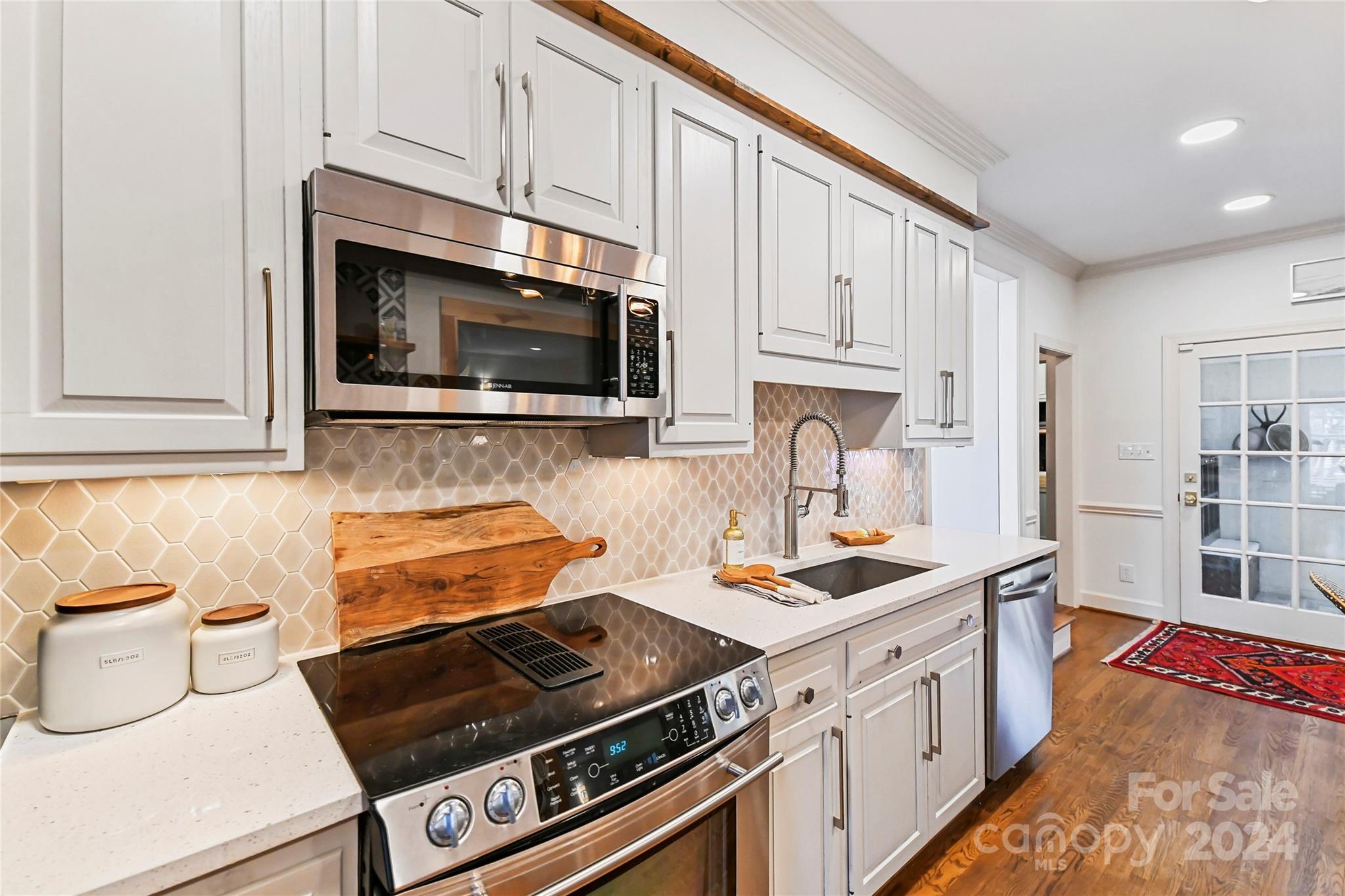 3023 High Ridge Road Charlotte, NC 28270 - Photo 9 of 48 a kitchen with stainless steel appliances a stove a microwave a sink and cabinets